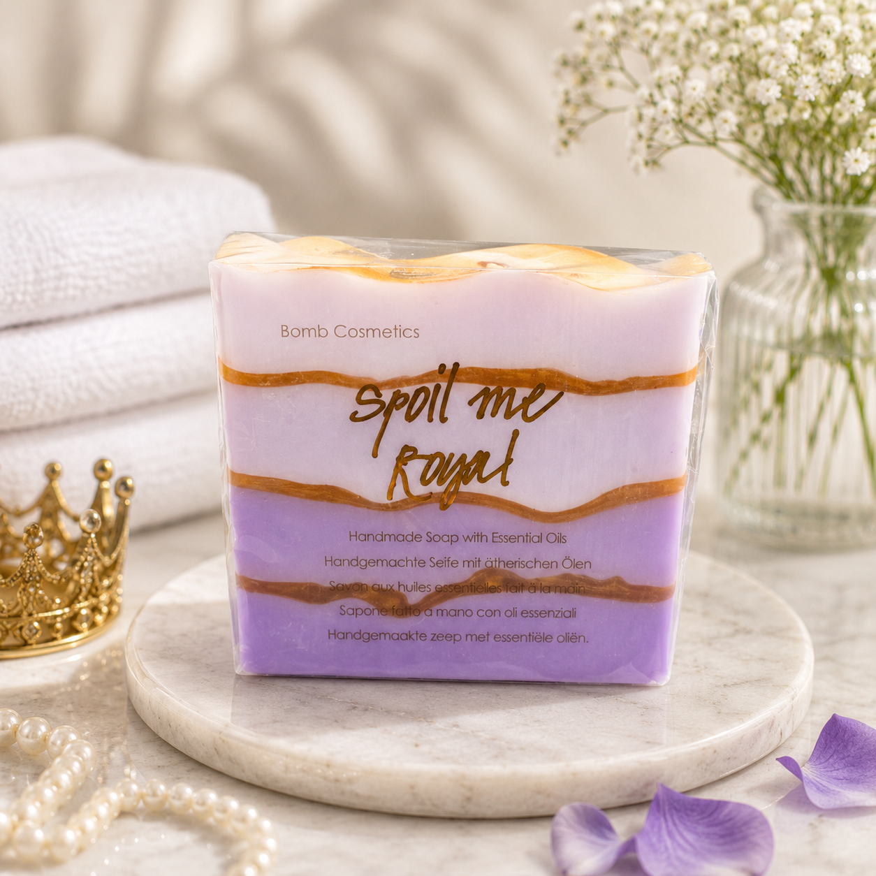 Handmade soap with 'Bomb Cosmetics' packaging on a marble surface with decorative elements.