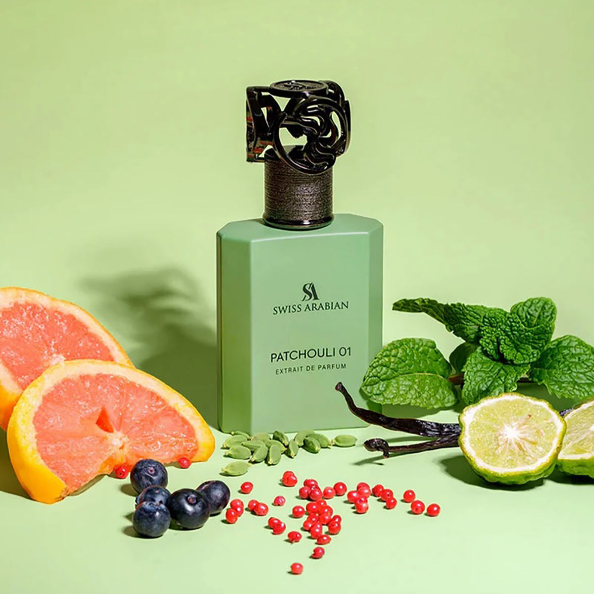 Swiss Arabian Patchouli 01 perfume bottle with fruits and mint leaves on a green background